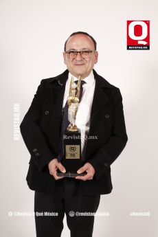 Lalo España con el premio de la revista Q