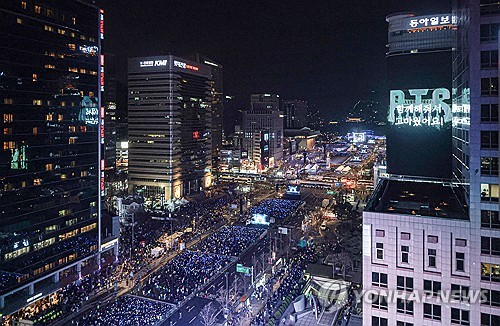 Una gran multitud de fans del K-pop se reúne en la plaza de Gwanghwamun, en Seúl, el 21 de marzo de 2026, para asistir a un concierto gratuito al aire libre para conmemorar el lanzamiento del quinto álbum de estudio de BTS, "Arirang".