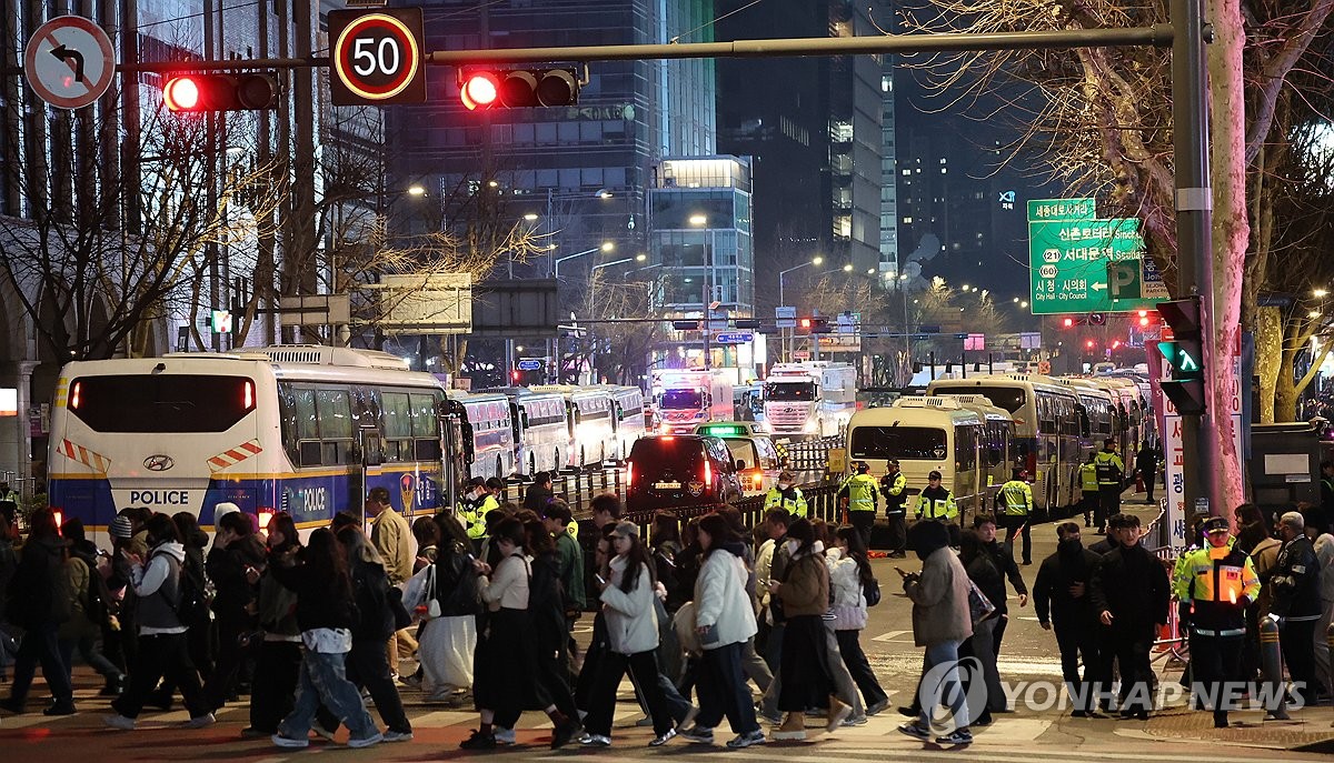 Los fans de BTS se desplazan bajo la guía de la policía, tras el final del concierto de regreso del grupo de K-pop, el 21 de marzo de 2026, en la plaza de Gwanghwamun, en el centro de Seúl.