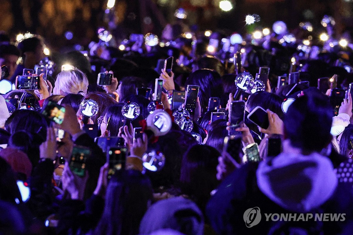Los fans de BTS sostienen barras de luz mientras ven una actuación en vivo de la superestrella del K-pop BTS, el 21 de marzo de 2026, en la plaza de Gwanhwamun, en el centro de Seúl.