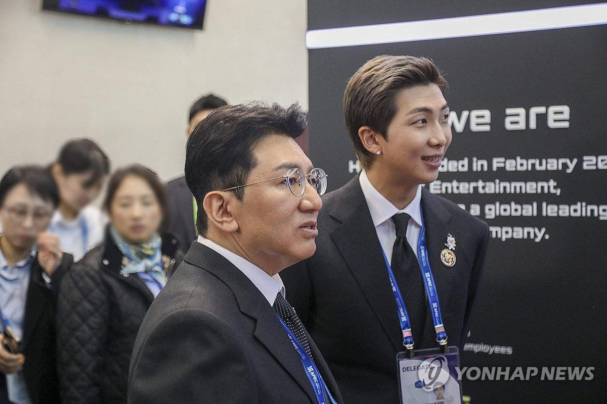 La foto de archivo, proporcionada por Hybe, muestra a su presidente, Bang Si-hyuk (izda.), asistiendo a un evento del Foro de Cooperación Económica Asia-Pacífico, el 29 de octubre de 2025, en la ciudad suroccidental de Gyeongju, junto con el integrante de BTS RM. (Prohibida su reventa y archivo)