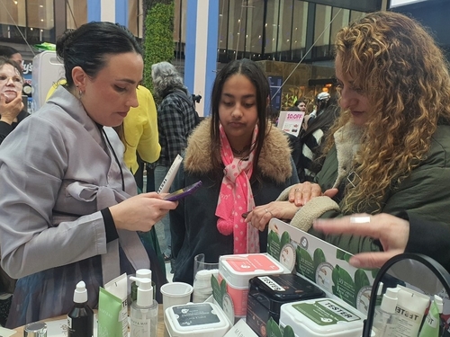 Unas ciudadanas argentinas experimentan los cosméticos surcoreanos, el 21 de agosto de 2026 (hora local), en un estand en el evento "Viví Corea", organizado por el Ministerio de Agricultura, Alimentación y Asuntos Rurales y la Agencia para la Promoción del Comercio e Inversión de Corea del Sur (KOTRA, según su acrónimo en inglés), en el centro comercial Abasto Shopping, en Buenos Aires, Argentina. 